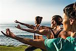 Women on cliff, practising yoga