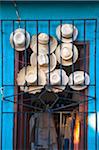 Close-up of straw hats displayed in doorway for sale, Trinidad, Cuba, West Indies, Caribbean