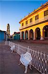 White metal chairs and fence in front of Museo Romantico with San Francisco Convent in background, Trinidad, Cuba, West Indies, Caribbean