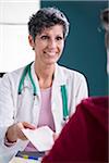 Doctor talking with Teenage Patient in Doctor's Office