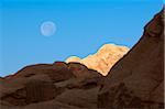 Rock formations and moon in early morning sky, Petra, Jordan