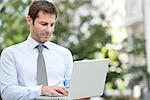 Businessman using laptop outdoors