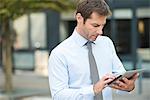 Businessman using digital tablet outdoors