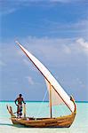 Maldives, Rasdhoo Atoll, Kuramathi Island. A Maldivian man sails a traditional Dhoni. MR.