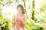 Brunette beauty standing in a forest on a sunny day