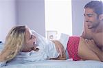 Attractive young couple lying on a bed in the bedroom