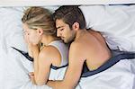 Attractive calm couple sleeping in their bed in the bedroom