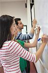 Students writing on the whiteboard together in class at the university