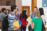 Happy students chatting together in a hallway at the university