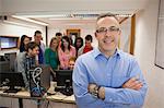 Computer teacher standing in front of his class in college