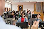 Cheerful students listening to lecturer in their computer class at the university