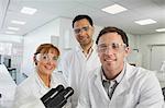 Group of scientists posing in laboratory smiling at camera