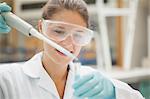 Attractive student holding big pipette in lab at college