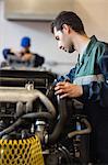 Focused instructor checking a machine in workshop