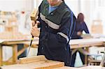 Craftsman using mallet and chisel in workshop
