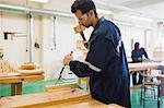 Focused craftsman using mallet and chisel in workshop