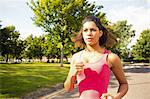 Beautiful healthy young woman jogging on pathway in the park