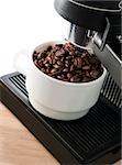 Close up coffee maker machine with white coffee cup and coffe bean