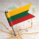 Small Flag of Lithuania Sticked in the Map Background with Selective Focus.