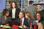 Four business people meeting with laptop on lunch table