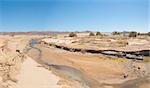 Small desert stream running through an oasis in arid desert landscape