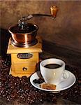 Coffee mill, cup of coffee and coffee beans