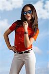 pretty girl with brown hair wearing fashion casual clothes red shirt and white jeans . on blue sky