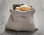 baby potatoes in sack bag on wood table