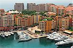 Marina with yachts and boats between contemporary buildings in Monte Carlo, Monaco (view from above).