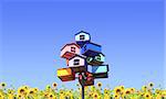 Colorful nesting boxes and sunflowers on blue sky