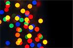 defocused colorful christmas lights on black background