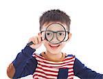 adorable boy holding a magnifier and watching through