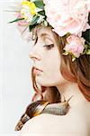 calm pretty girl with snail and flower crown on head on white background