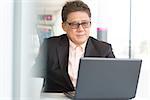 Asian Chinese CEO boss using internet with laptop at cafe. Senior male businessman.