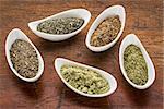 bowls of seaweed diet supplements (bladderwrack, sea lettuce, kelp, wakame and Irish moss) on a rustic wood table