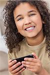 Beautiful young mixed race interracial African American girl child smiling with perfect white teeth using smart cell phone for texting or playing video games