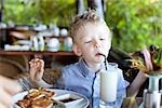 cute little boy drinking his milk at the breakfast, delicious breakfast at the resort