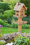 Homemade bird house nexto to a pond in the backyard