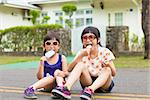 little Girls  Eating Ice Cream and sitting before their house