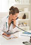 Thoughtful medical doctor woman with fluorography and holding phone