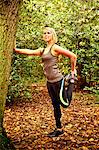 Woman stretching legs in woods