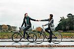 Young couple cycling on street
