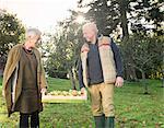 Senior couple carrying crate of apples