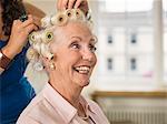 Senior woman with rollers at hairdressers