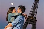 Young couple embracing in moonlight, Paris, France