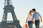 Young couple kissing near Eiffel Tower, Paris, France