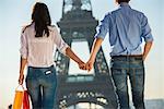 Young couple strolling in front of  Eiffel Tower, Paris, France