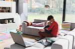 Mother with baby boy sitting on sofa at home