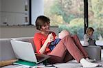 Mother, baby boy and female toddler in sitting room