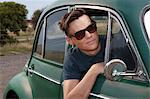 Young man leaning out of vintage morris minor